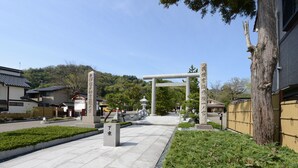 Une porte japonaise traditionnelle, avec des piliers en pierre et une structure en bois.