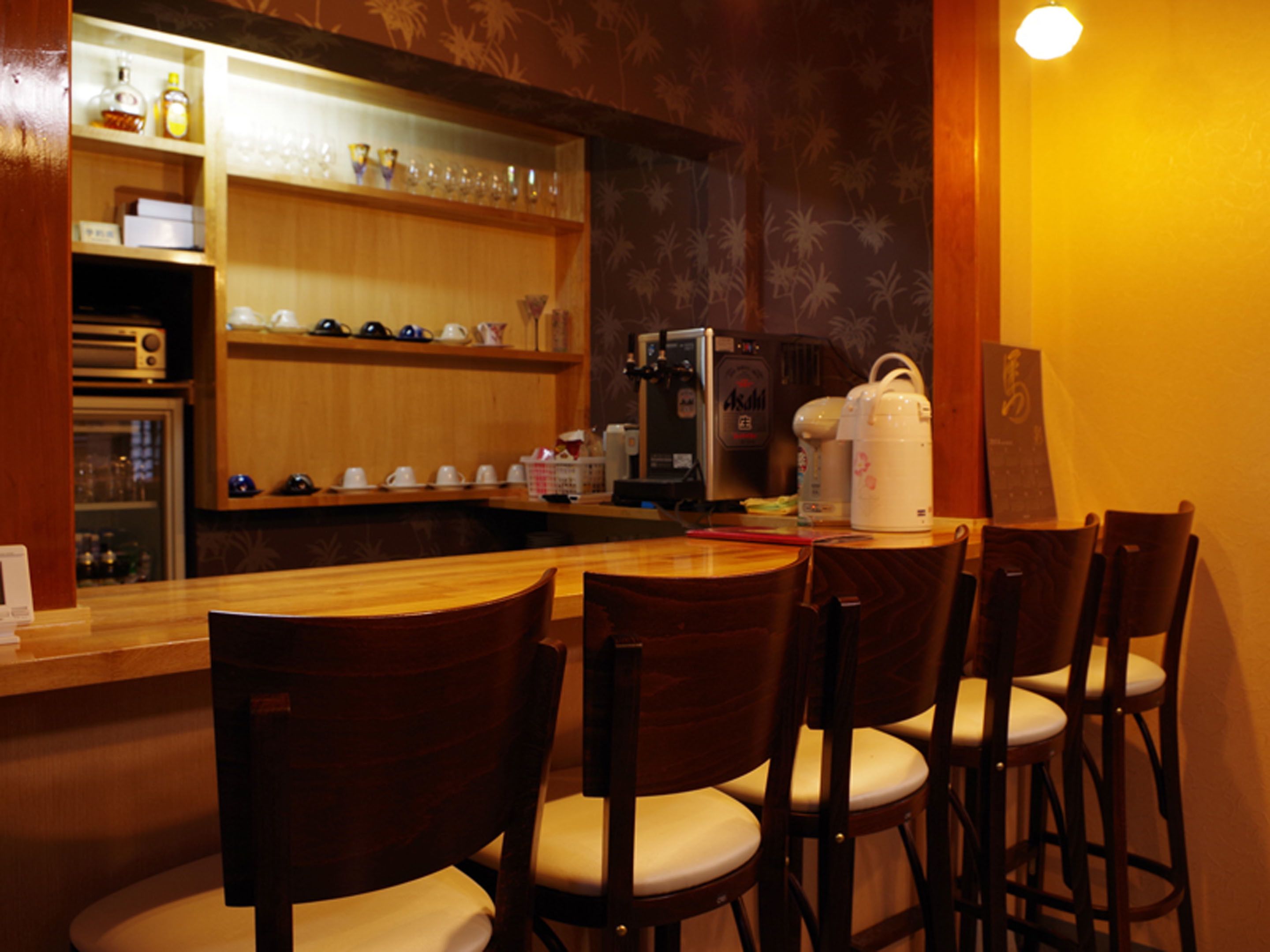 A bar area with wooden chairs and a counter.