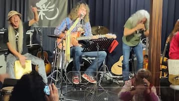 A band performing on a stage with musical instruments and a drum set.