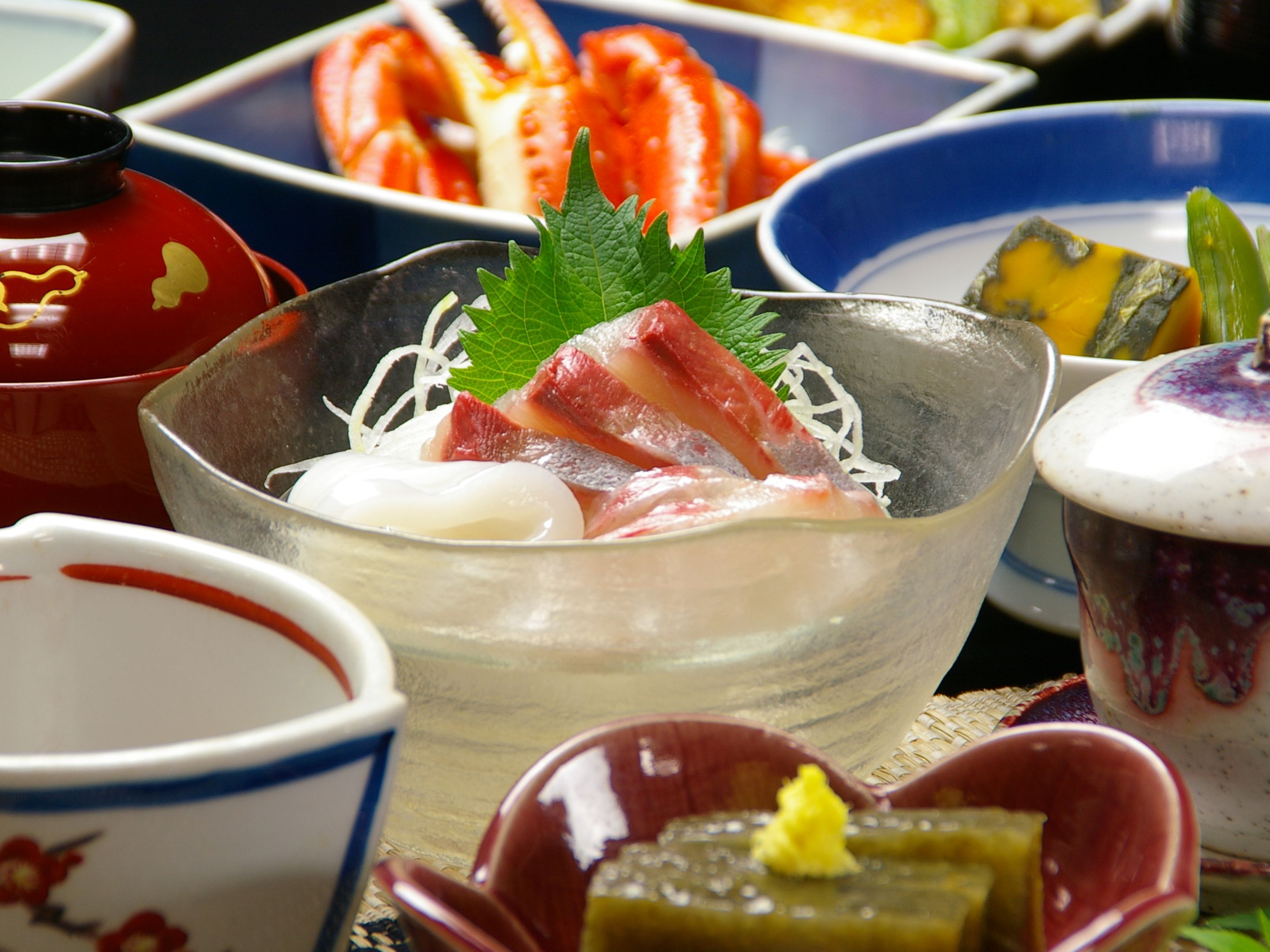 A variety of dishes, including seafood and vegetables, arranged on a table.