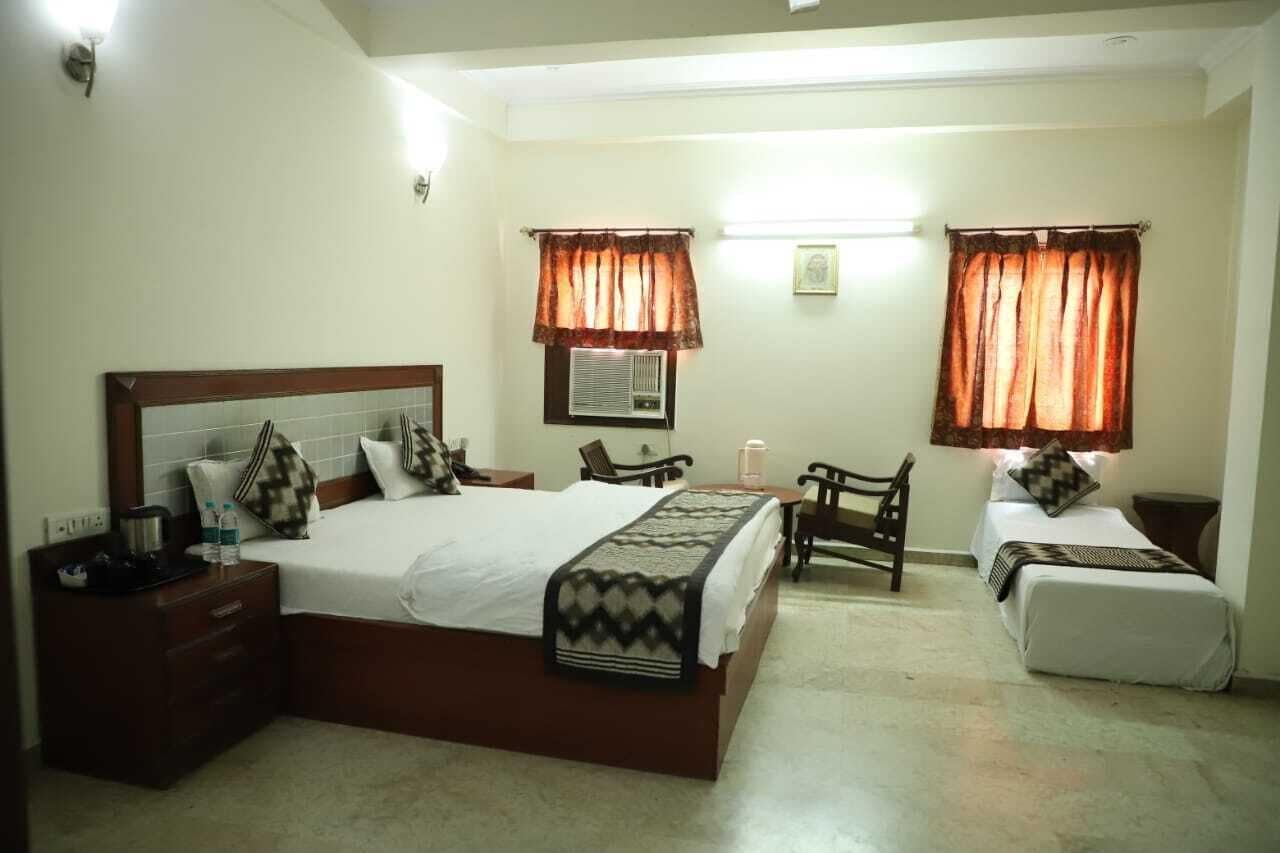 A hotel room with a large bed, two bedside tables, a desk, and two chairs.