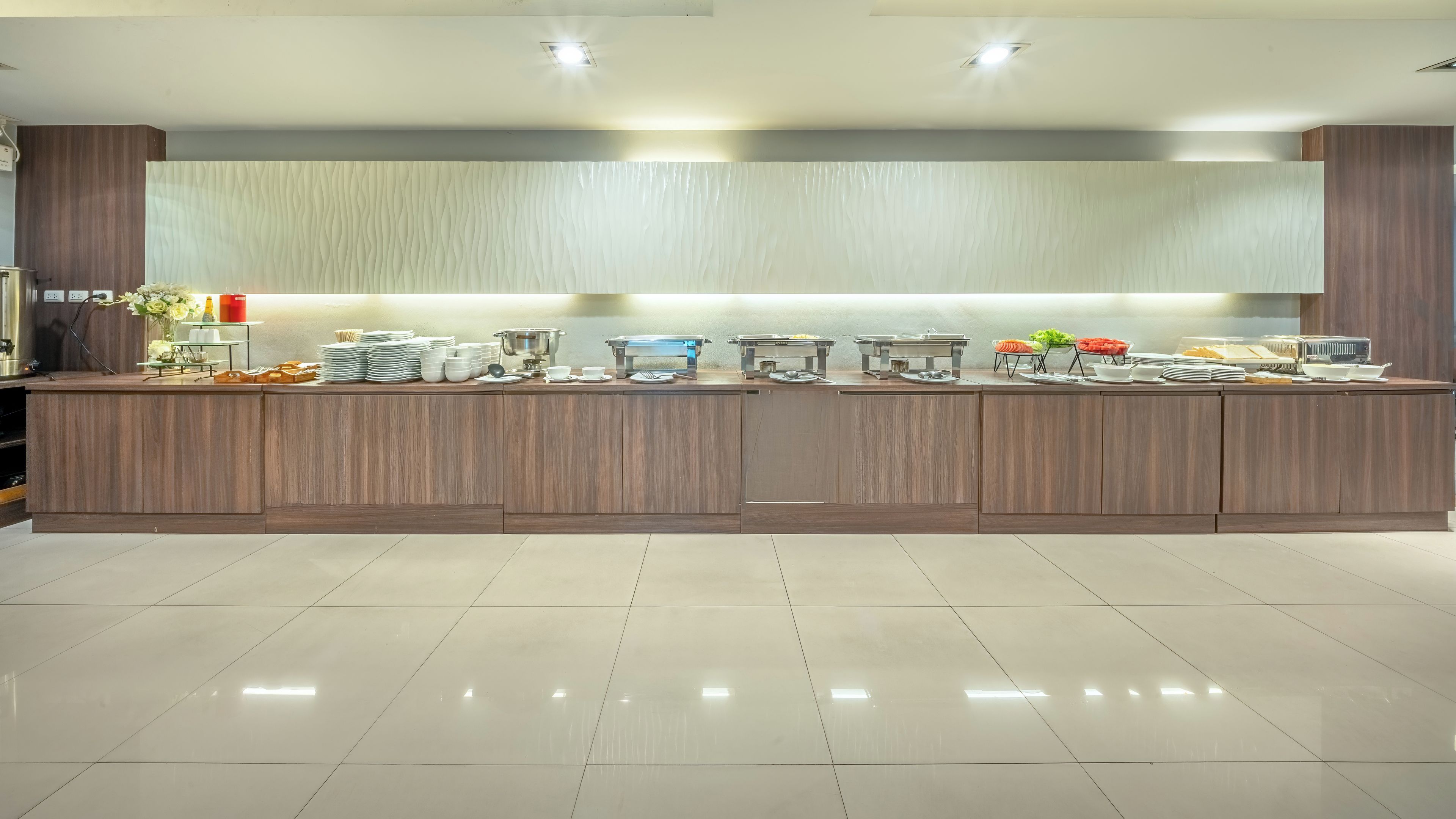 Una cocina moderna con una encimera larga, equipada con electrodomésticos y utensilios varios.