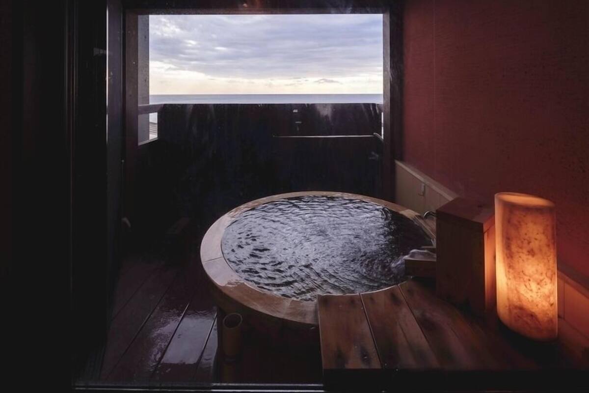 A hot tub with a view of the sky through a window.