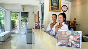 A reception area with a Buddha statue, a clock, and a signboard for a hotel. - Pova Residence and Boutiques Resort (Chonburi)