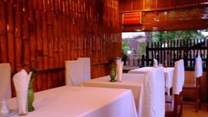 A restaurant with white tablecloths and wooden walls.
