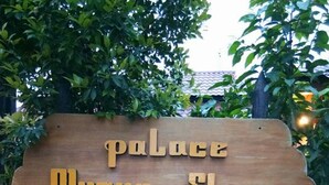 A wooden sign with the text "palace Myaung Shwe Guest House".