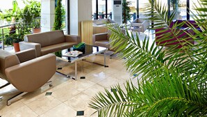 A spacious lobby with a high ceiling, large windows, and a mix of seating areas including sofas and a coffee table. - Ayvalik Cinar Hotel (Ayvalik)