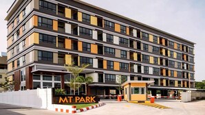 A multi-story hotel with a modern design, featuring a prominent entrance and a sign that reads "MT PARK". - MT Park Residence (Chonburi)