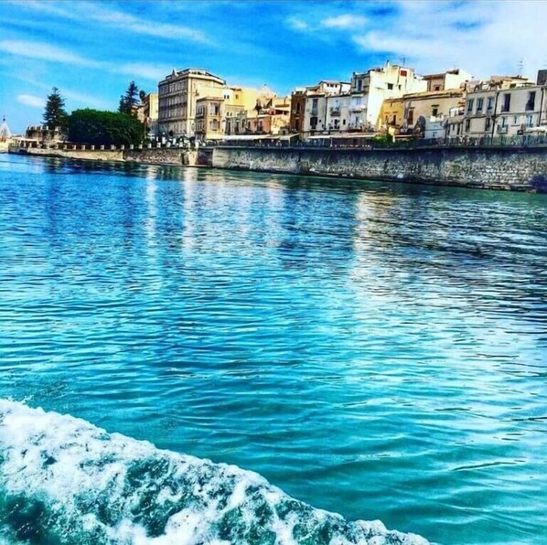 A waterfront view with buildings along the shore. - Rudy Arenaile (Syracuse)