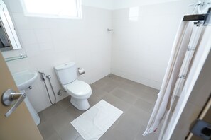 Un baño moderno con inodoro, lavabo y ducha.