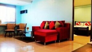 Una sala de estar moderna con un sofá rojo, una mesa de centro y un comedor con sillas.