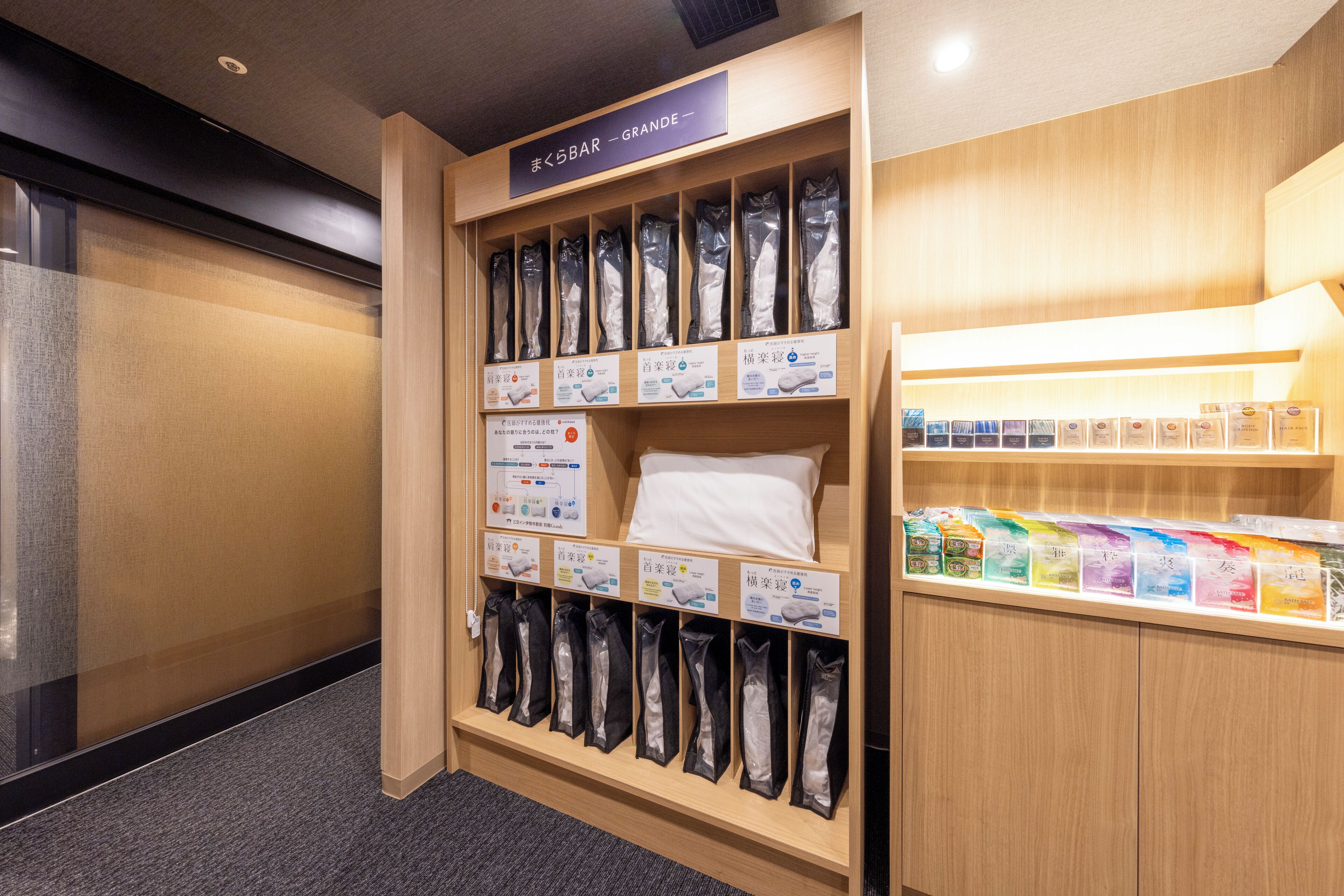 A hotel room with a wooden cabinet displaying various toiletries and a sign indicating a minibar area.
