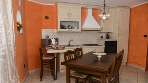 Une cuisine équipée d’une table et de chaises, d’un évier, d’une cuisinière et de placards.
