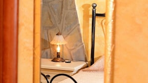 Un lit avec un cadre en métal, une table de chevet et une lampe.
