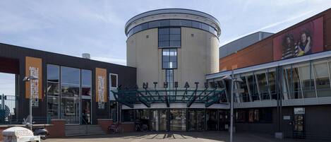 A modern building with a circular central section and a glass entrance.