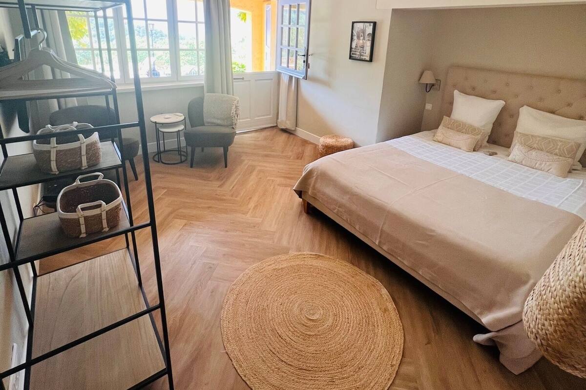A bedroom with a bed, a desk, and a chair.