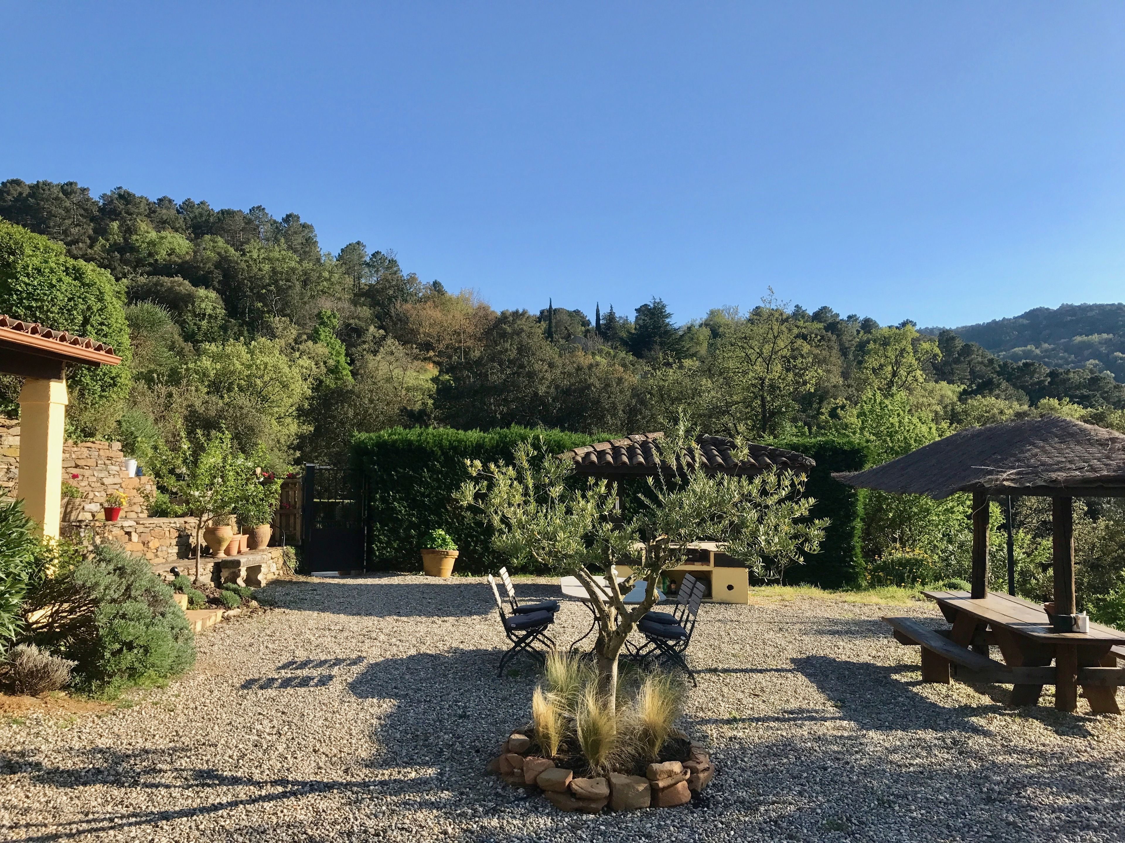 Eine Terrasse mit Pergola, Sitzgelegenheiten und einem Pavillon.