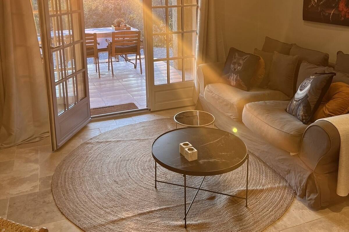 A living room with a sofa, a coffee table, and a painting on the wall.