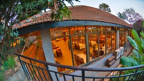 A restaurant with a tiled roof, large windows, and outdoor seating. - Arirang Hotel (Kampala)