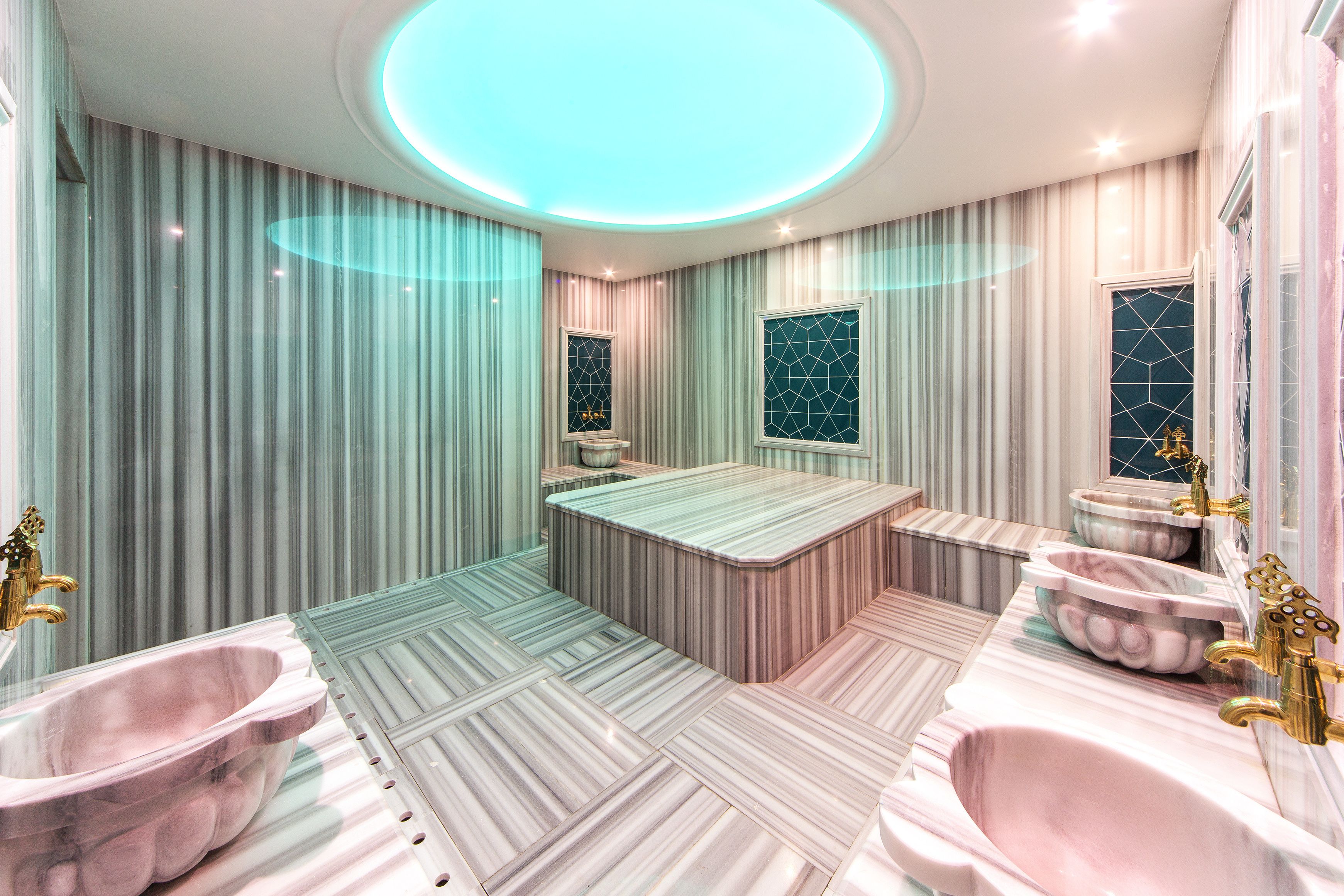 A modern bathroom with a central island, two sinks, and a vanity.