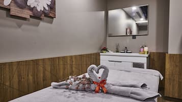 Experience a clean and contemporary space with a large mirror, a neatly made bed, and a modern bathroom featuring a vanity and toiletries.