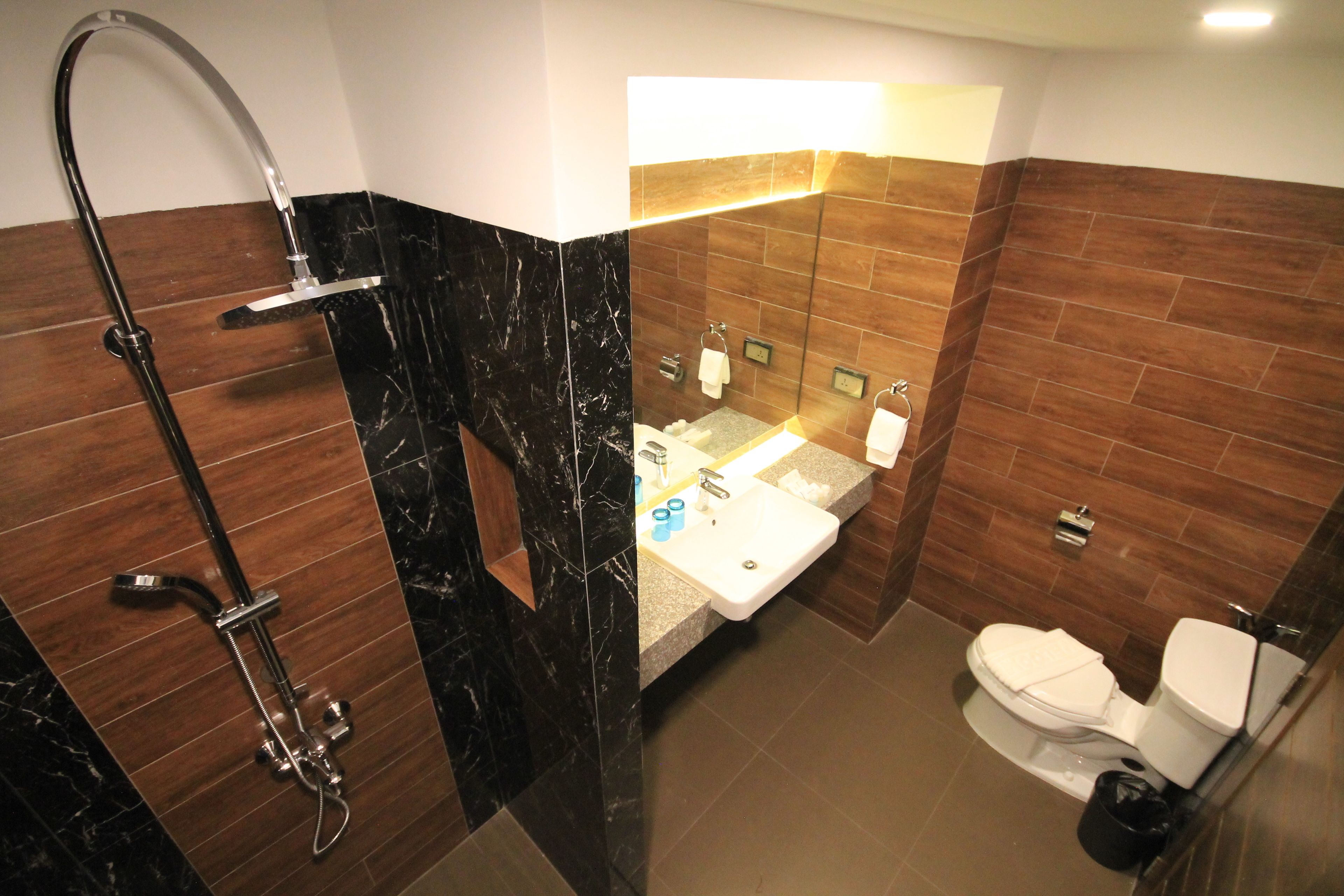 A modern bathroom with a shower, sink, and toilet.