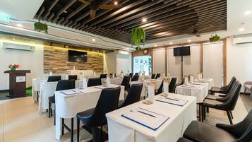 A conference room with tables set for meetings, equipped with chairs, nameplates, and a podium.