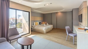 Une chambre d’hôtel moderne dotée d’un grand lit, d’un bureau, d’une chaise et d’un balcon offrant une vue sur la ville.