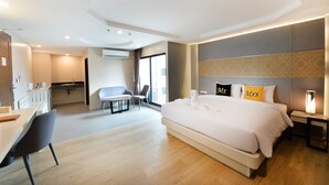 Une chambre d’hôtel moderne, dotée d’un grand lit, d’un bureau et d’une chaise.