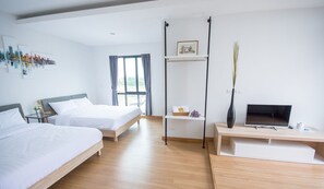 Relax in a serene space with two single beds, a large window, and a ceiling-mounted bed rail.