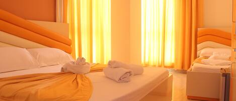A hotel room with a bed, a bedside table, and a wardrobe.