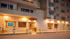 A hotel entrance with a modern facade, a visible reception desk, and a gated entrance. - Hapi Hotel (Aswan)