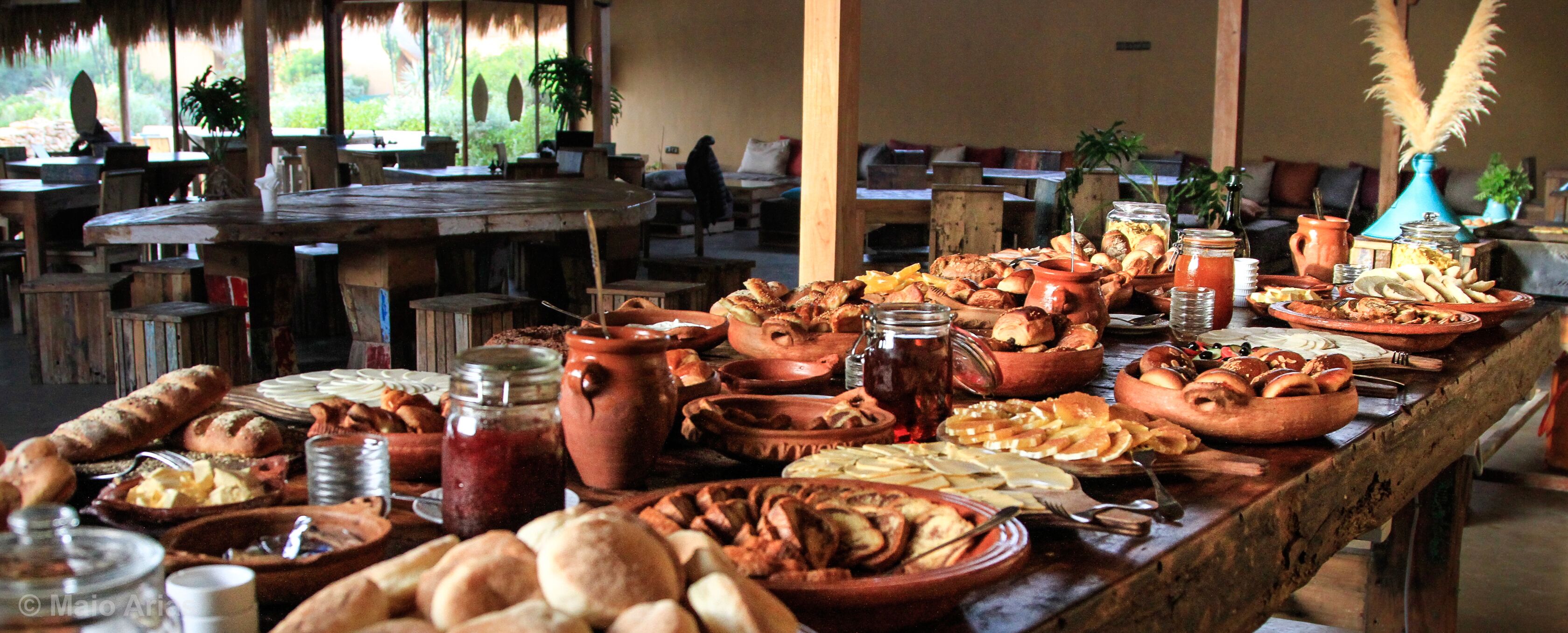 Una mesa de buffet con diversos alimentos y utensilios para servir.
