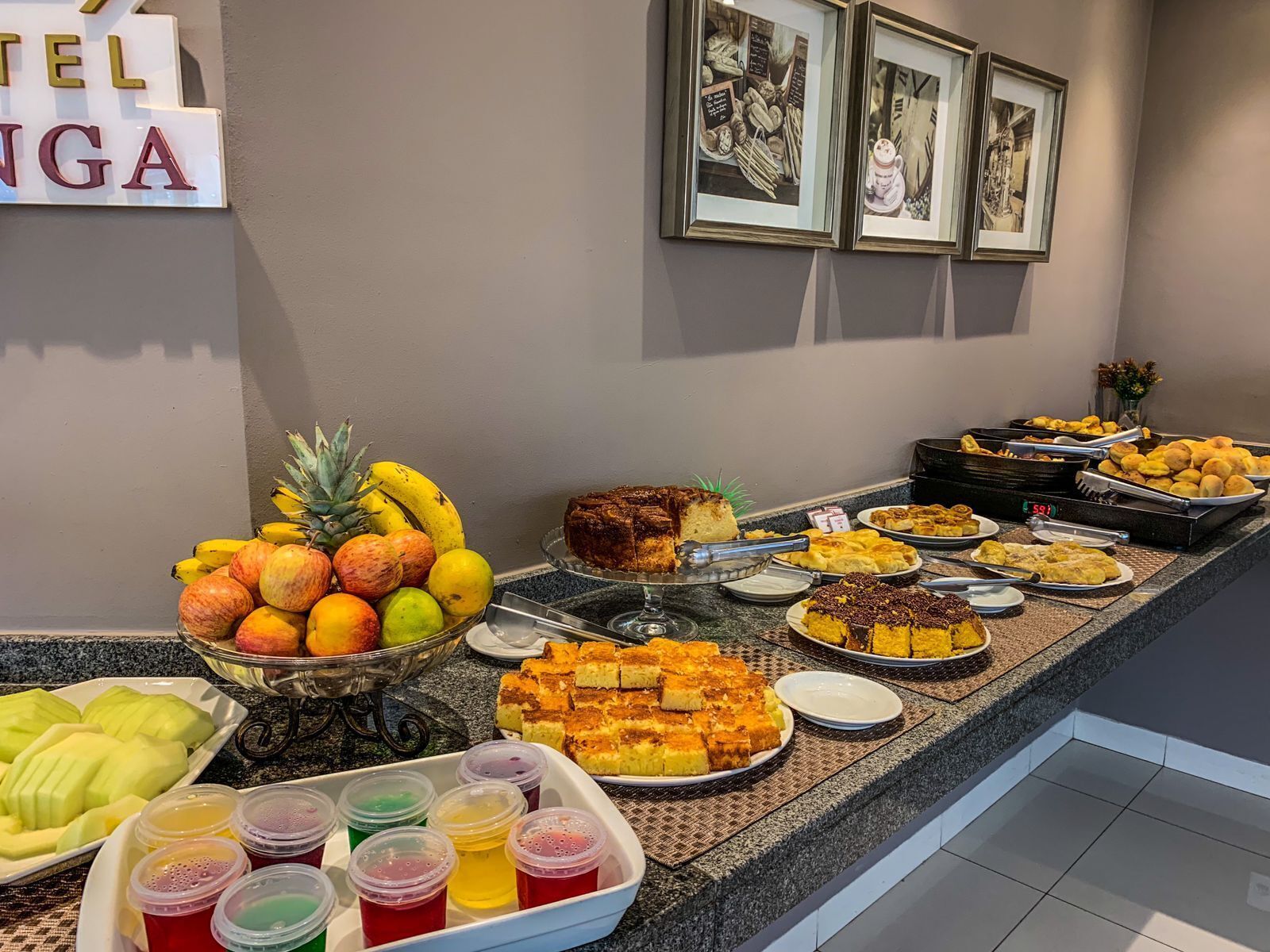 A buffet with various food items including fruits, cakes, and desserts.