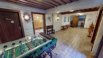 Relax in a room with a foosball table and seating area.