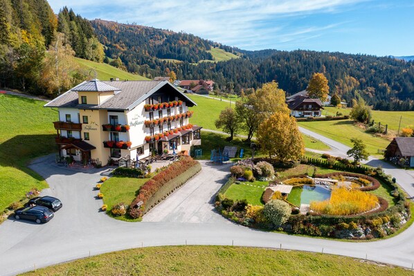 A hotel with a large balcony, a swimming pool, and a scenic mountain backdrop. - Berghotel Presslauer (Hermagor-Pressegger See)
