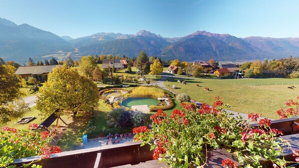 A scenic view of a mountainous area with a small village, houses, and a pond. - Berghotel Presslauer (Hermagor-Pressegger See)