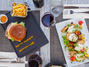 A meal with a burger, fries, and a salad on a table. - The Originals City, Hôtel de la Confluence (Damazan)