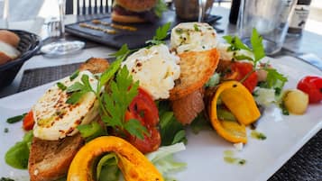 A plate of food with grilled chicken, vegetables, and bread.