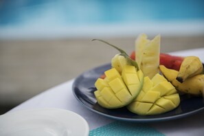 A plate with sliced mango and bananas on a table. - Auberge Chez Plume (Mahé Island)