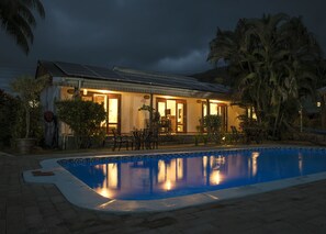 Una piscina al aire libre, sombrillas, sillones reclinables de piscina