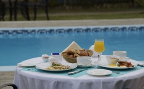 Enjoy a leisurely breakfast by the pool, surrounded by a delicious spread of pastries, eggs, and fresh juice.