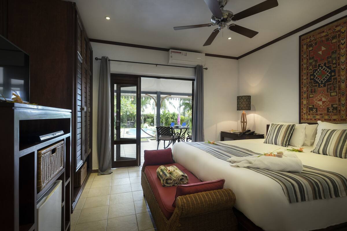 A hotel room with a bed, a television, a desk, and a view of the outdoors.