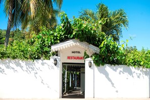 Enter a tranquil oasis with lush greenery surrounding the entrance to our hotel and restaurant.