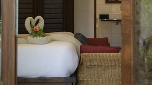 A bedroom with a bed, a bench, a ceiling fan, and a mirror. - Auberge Chez Plume (Mahé Island)