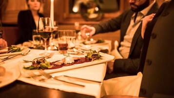 A dining table set with plates, cutlery, glasses, and a candle.
