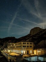 Un hotel con un cartel llamativo que dice 'PILATUS-KULM' bajo un cielo estrellado.
