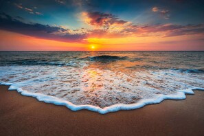 Una playa con olas al atardecer.