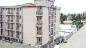 A multi-story building with balconies, a 'Stayeasy' sign, and a flag. - Stay Easy (Addis Ababa)
