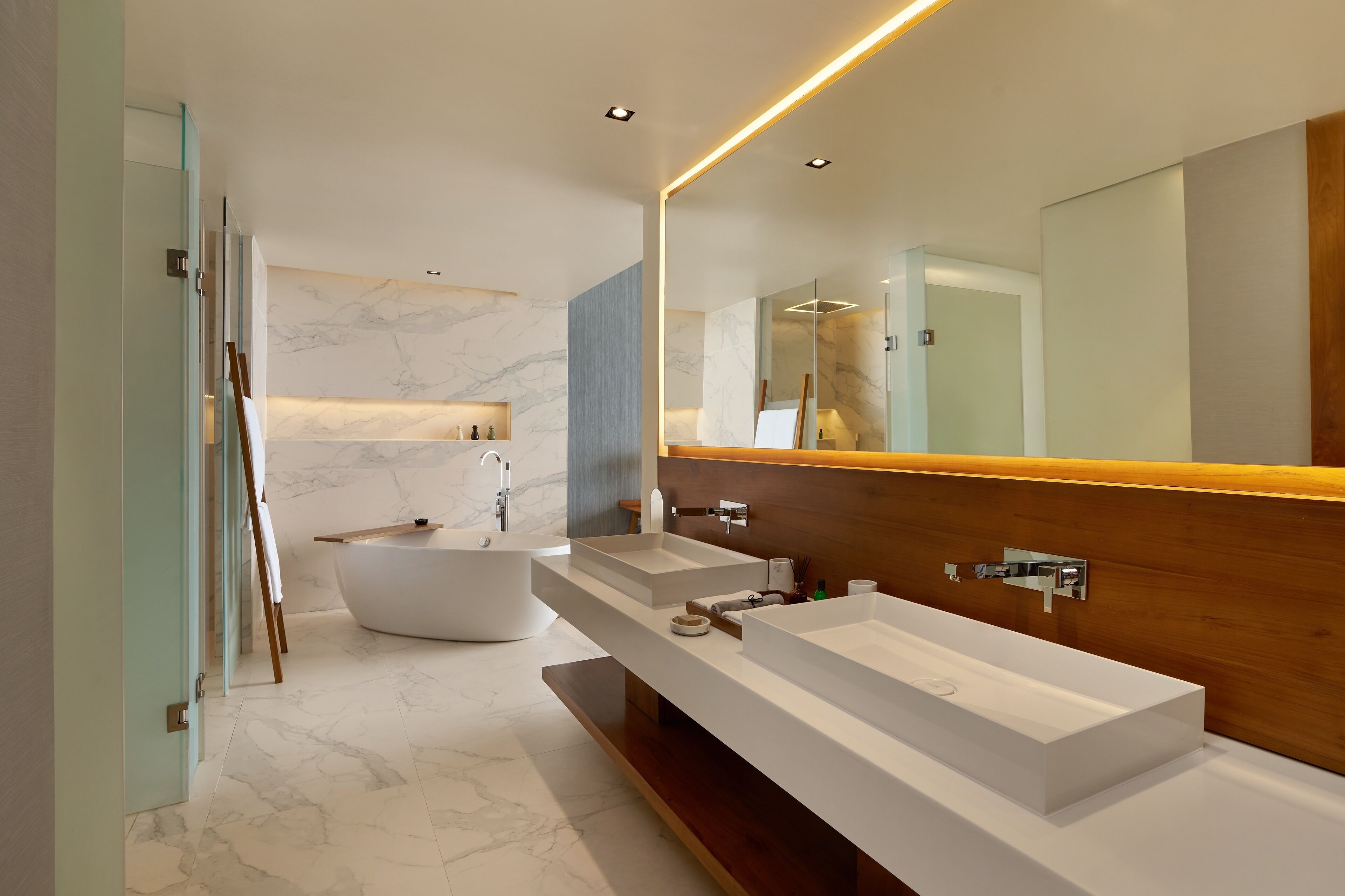 Une salle de bain moderne avec une baignoire sur pieds, deux lavabos et un grand miroir.